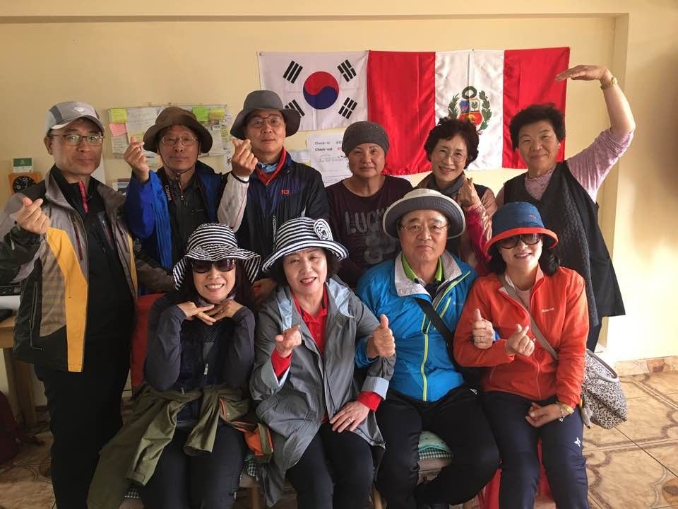 태극기 앞에 모인 단체 손님들과 이모
